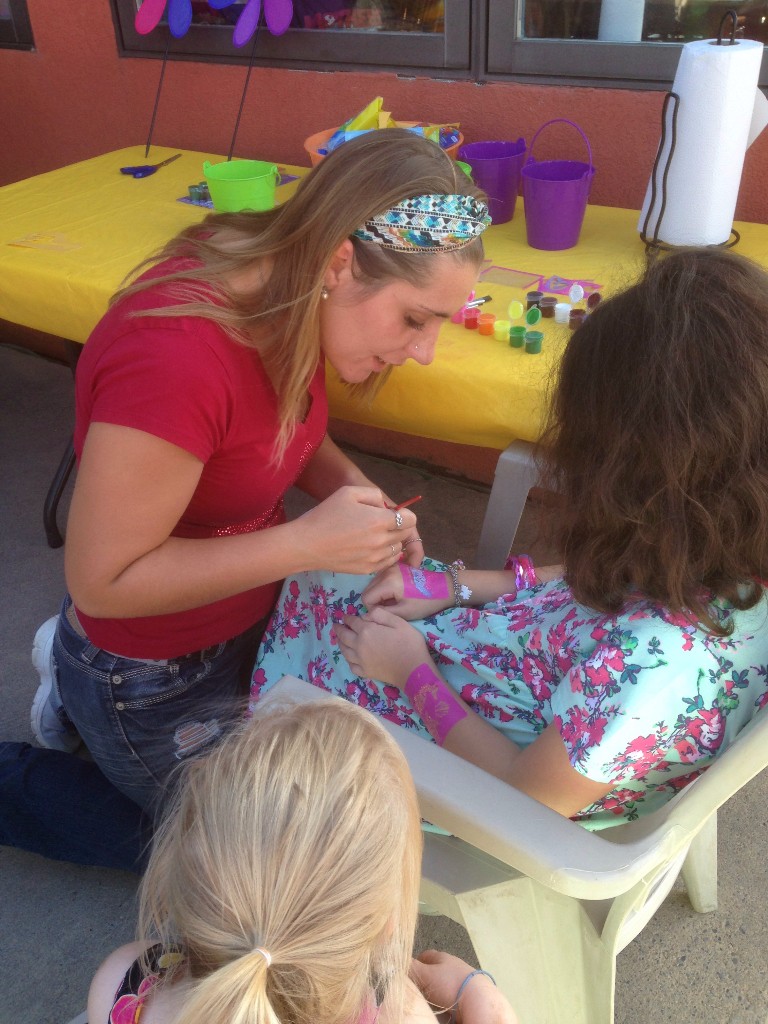 Two women at a face painting table during a Trapper's Pizza Pub event