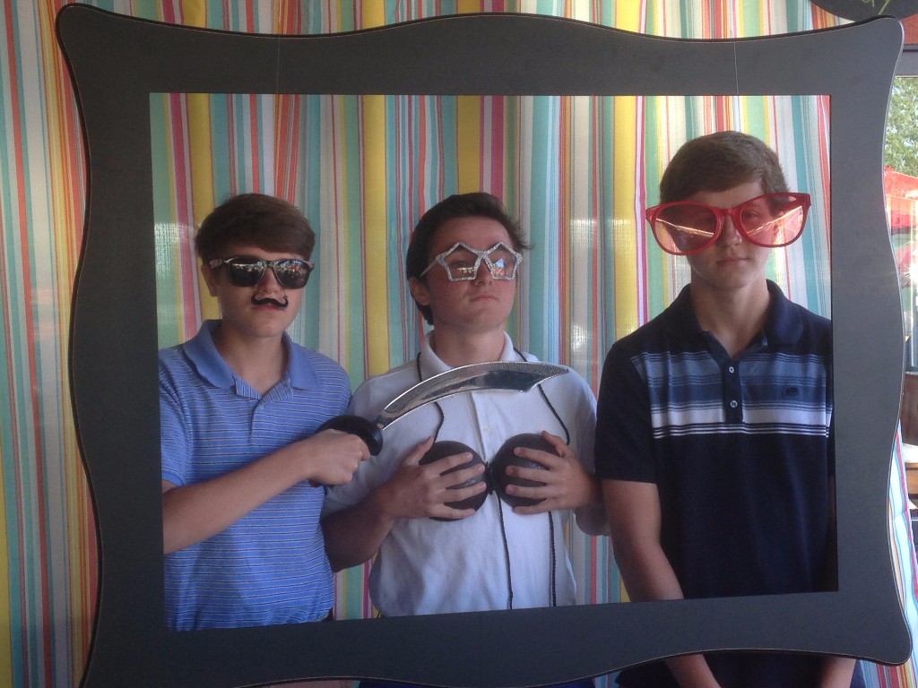 Three boys wear silly masks in a frame at a party held at Trapper's Pizza Pub