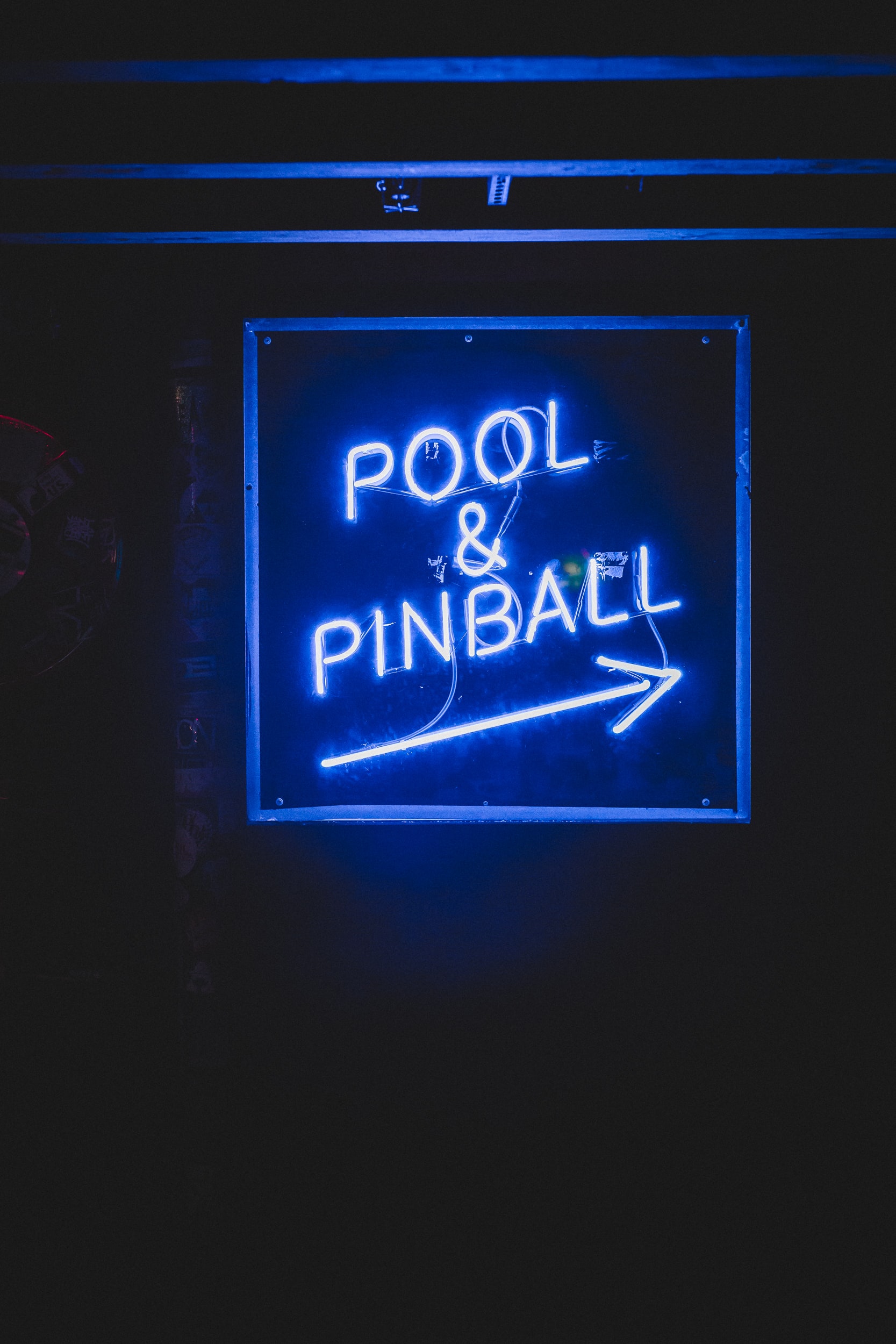 Neon blue Pool & Pinball sign with an arrow. 